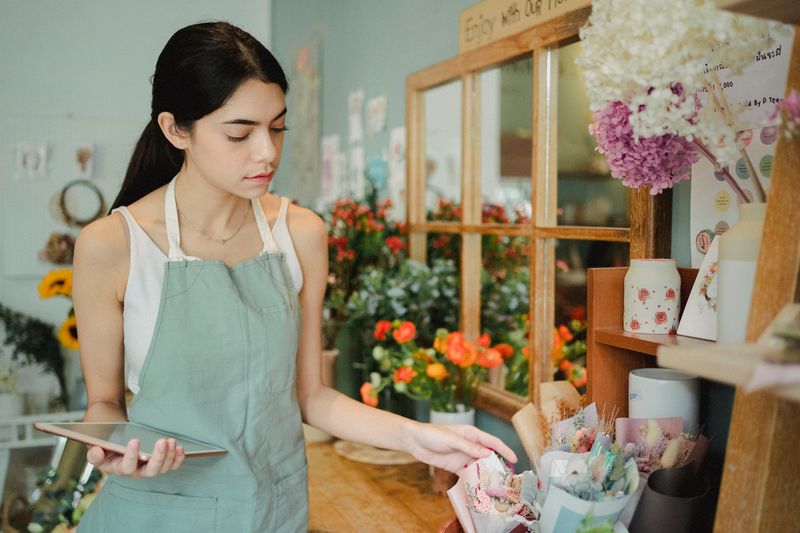 Bloemiste bekijkt in haar winkel een bestelling op een tablet